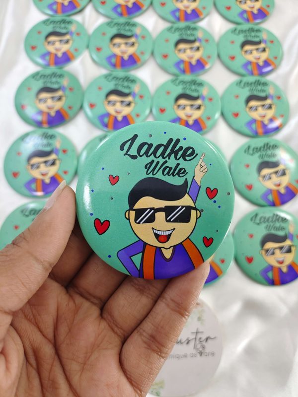 a mint-green LadkeWale Printed Brooches featuring a cartoon man in sunglasses and a traditional outfit with "Ladke Wale" written above him accessory for groom's side members during wedding ceremonies, baraat day, or nikah events