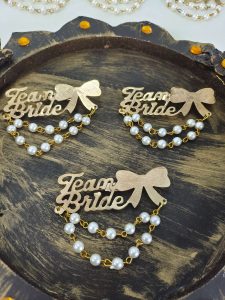 handcrafted Team Bride brooches featuring pearl embellishments, perfect for wedding favors and bridesmaid gifts