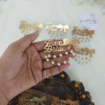 Team Bride brooches with a gold bow and pearls is a stylish accessory for bridal parties and wedding attire