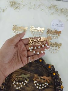 Team Bride brooches with a gold bow and pearls is a stylish accessory for bridal parties and wedding attire