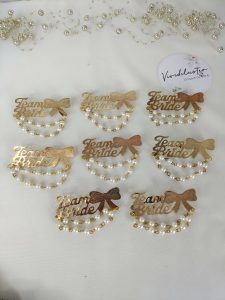 Team Bride brooches featuring pearls and a gold bow, perfect for wedding favors, bride side badges, and lehenga accessories