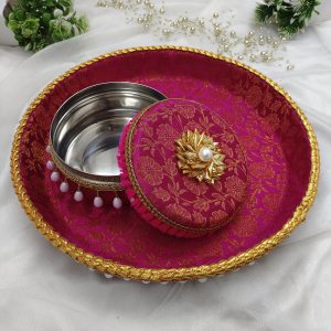 Decorative red and gold round bangles ceremony trays with white bead accents, featuring a smaller matching lidded container both adorned with intricate gold detailing and white bead accents. The vibrant red fabric features a subtle floral pattern