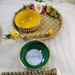 Golden Haldi ceremony platter with intricate lacework, pearl accents, and bright yellow flowers for Haldi, Mehndi, or Nikah ceremonies, it adds a touch of sophistication to your wedding rituals and serves as a delightful wedding favor
