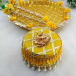 Charming yellow and gold steel platter with a lattice design, golden trims, and yellow flower accents, featuring a round box for Haldi and Henna ceremonies The centerpiece round steel box, with its pearl accents, is ideal for holding Haldi, Henna, or other special items wedding favor