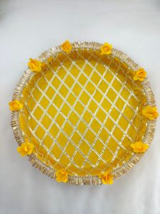 Decorative yellow and gold steel platter featuring a lattice pattern, golden trims, yellow flower accents, and a centerpiece round box for Haldi and Henna ceremonies This platter is a wonderful way to add a touch of tradition and elegance to your special day