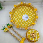Bright yellow and gold steel platter for Haldi and Henna ceremonies, featuring a lattice design with golden trims and adorned with yellow flowers and a pearl-accented round steel box This decorative platter is a charming way to celebrate your joyous moments and makes a delightful gift for any bride-to-be