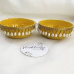 Charming yellow and gold steel bowl with a lattice design, golden trims, and yellow flower accents, featuring a round box for Haldi and Henna ceremonies The centerpiece round steel haldi box, with its pearl accents, is ideal for holding Haldi, Henna, or other special items wedding favor