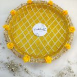Decorative yellow and gold steel platter featuring a lattice pattern, golden trims, yellow flower accents, and a centerpiece round box for Haldi and Henna ceremonies This platter is a wonderful way to add a touch of tradition and elegance to your special day