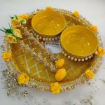 Beautiful yellow and gold steel platter for Haldi and Henna ceremonies, adorned with floral accents and decorative details The centerpiece features a beautifully crafted round box with pearl accents, perfect for holding Haldi, Henna wedding favor