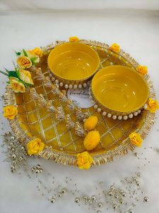 Beautiful yellow and gold steel platter for Haldi and Henna ceremonies, adorned with floral accents and decorative details The centerpiece features a beautifully crafted round box with pearl accents, perfect for holding Haldi, Henna wedding favor