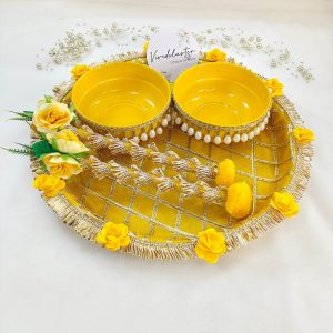 Bright yellow and gold steel platter for Haldi and Henna ceremonies, featuring a lattice design with golden trims and adorned with yellow flowers and a pearl-accented round steel bowl This decorative platter is a charming way to celebrate your joyous moments and makes a delightful gift for any bride-to-be