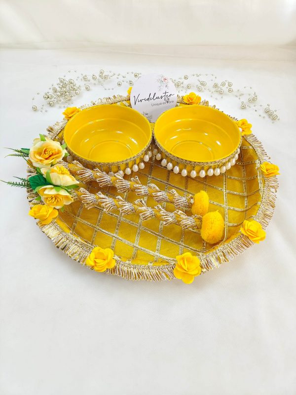 Bright yellow and gold steel platter for Haldi and Henna ceremonies, featuring a lattice design with golden trims and adorned with yellow flowers and a pearl-accented round steel bowl This decorative platter is a charming way to celebrate your joyous moments and makes a delightful gift for any bride-to-be