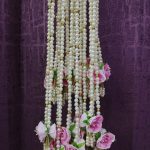 Beautifully crafted moti haar milni malas featuring pearls interspersed with gold accents and adorned with lush pink roses, ideal for traditional Punjabi milni gifts and wedding guest malas.