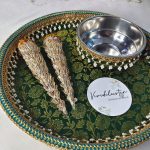 A green and gold wedding mehndi platter with two ornate cones and a stainless steel bowl, adorned with pearls and lace, ideal for traditional wedding ceremonies