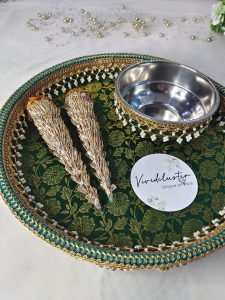 A green and gold wedding mehndi platter with two ornate cones and a stainless steel bowl, adorned with pearls and lace, ideal for traditional wedding ceremonies