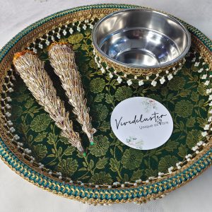 A beautifully decorated wedding mehndi platter featuring intricate designs. The green and gold platter includes two ornate cones and a stainless steel bowl, embellished with pearls and lace, ideal for wedding ceremonies