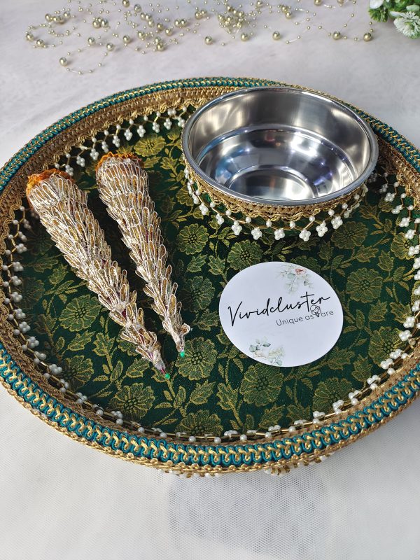 A beautifully decorated wedding mehndi platter featuring intricate designs. The green and gold platter includes two ornate cones and a stainless steel bowl, embellished with pearls and lace, ideal for wedding ceremonies