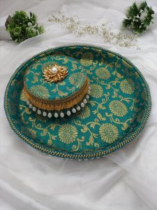 Green and gold bangle chura ceremony platter with intricate floral motifs and pearl tassel border serve as a decorative piece for various wedding functions