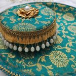 Beautiful green and gold ceremonial platter with detailed floral design and pearl accents for wedding rituals The centerpiece, featuring a golden floral motif with a central pearl, elevates the traditional chura ceremony