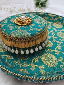 Beautiful green and gold ceremonial platter with detailed floral design and pearl accents for wedding rituals The centerpiece, featuring a golden floral motif with a central pearl, elevates the traditional chura ceremony