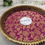 Decorative bangle ceremony platter in vibrant pink and gold floral design with intricate lace and pearl accents for showcasing bangles and jewelry during traditional ceremonies. This versatile platter adds elegance to any wedding function