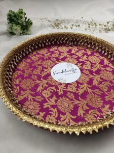 Decorative bangle ceremony platter in vibrant pink and gold floral design with intricate lace and pearl accents for showcasing bangles and jewelry during traditional ceremonies. This versatile platter adds elegance to any wedding function