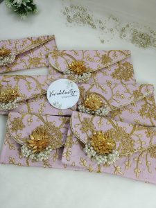 Handcrafted pink pearl envelope with golden floral embroidery, ideal for nikah ceremony favors