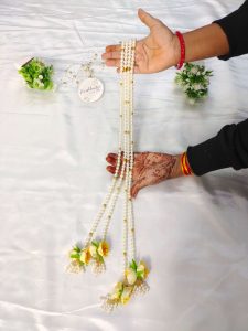 A beautiful moti haar adorned with vibrant yellow floral accents, designed to make nikah ceremonies and weddings extra special. This decorative mala serves as an exquisite wedding favor, guest mala