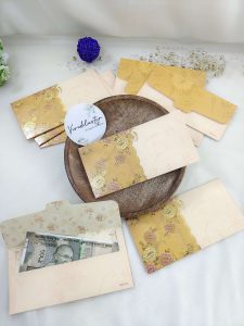 Designer shagun envelopes with rich golden detailing, perfect for wedding and engagement ceremonies