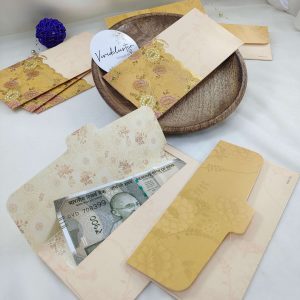 Gold-accented shagun envelopes with floral patterns, perfect for wedding ceremonies and gift giving