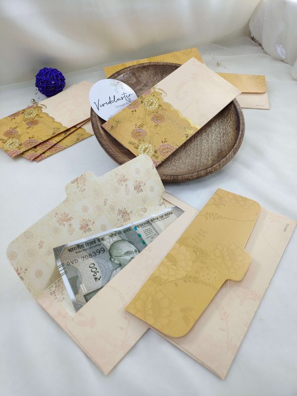 Gold-accented shagun envelopes with floral patterns, perfect for wedding ceremonies and gift giving