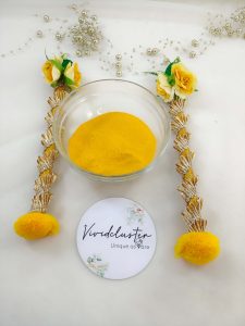 Charming Haldi dabber and bowl with a mix of vibrant flowers and yellow powder, perfect for adding a touch of elegance to wedding ceremonies a traditional wedding favor