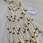 Wedding accessory featuring multi-layered pearls with gold and maroon details. Perfect for baaratis, this decorative flower milni mala also makes a thoughtful Punjabi milni gift