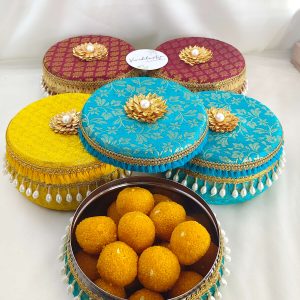 Colorful brocade wedding favor laddu boxs with delicate pearl tassels and gold lace perfect for storing wedding favors, sweets gifts, lovely keepsakes for special day
