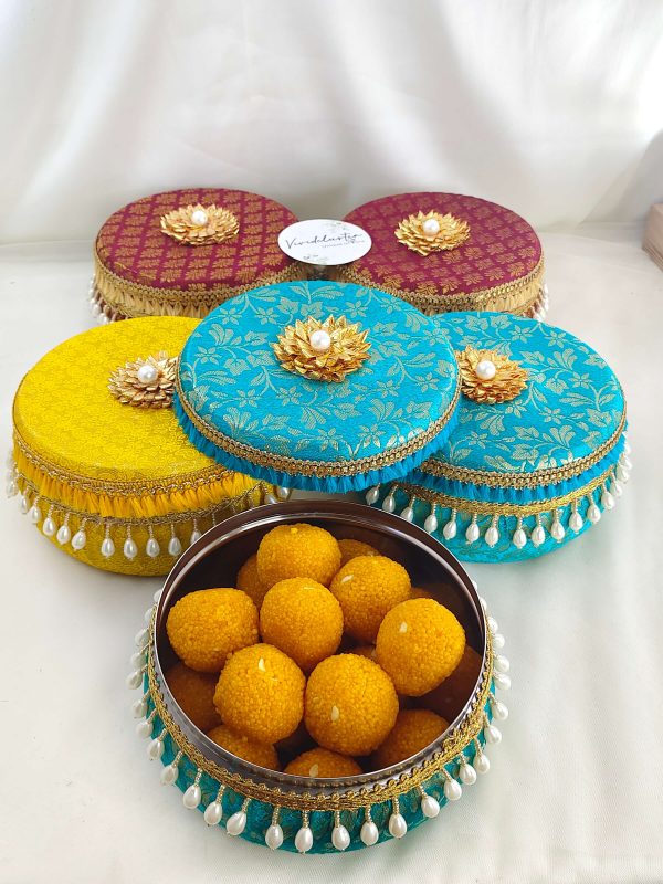 Colorful brocade wedding favor laddu boxs with delicate pearl tassels and gold lace perfect for storing wedding favors, sweets gifts, lovely keepsakes for special day