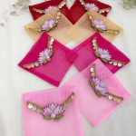 Set of lotus net shagun envelopes in various shades, decorated with golden lace and lotus motifs, perfect for wedding favor giveaways