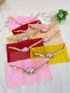 Set of lotus net shagun envelopes in various shades, decorated with golden lace and lotus motifs, perfect for wedding favor giveaways
