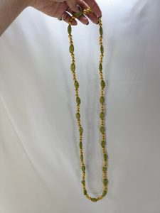Handcrafted wedding necklace featuring a stunning green beaded bridal mala with intricate golden details for your bride to look gorgeous in her haldi mehandi ceremony.