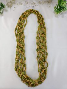 Handcrafted wedding necklace featuring a stunning green beaded bridal mala with intricate golden details for your bride to look gorgeous in her haldi mehandi ceremony.