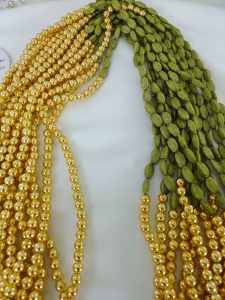 A beautifully detailed Welcome Milni Mala Moti Haar featuring Elachi and green and gold beads for weddings, guest welcomes, and bridesmaid gifts