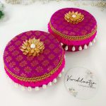 pink color , round laddu boxes adorned with gold patterns and pearl tassels keepsake for bridesmaids, these laddu boxes are a wonderful wedding laddu boxes