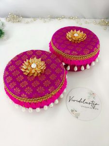 pink color , round laddu boxes adorned with gold patterns and pearl tassels keepsake for bridesmaids, these laddu boxes are a wonderful wedding laddu boxes