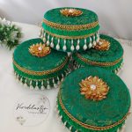 green color, round Wedding giveaway laddu boxs adorned with gold patterns and pearl tassels keepsake for bridesmaids, these laddu boxes are a wonderful wedding laddu boxes