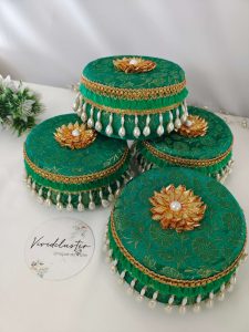 green color, round Wedding giveaway laddu boxs adorned with gold patterns and pearl tassels keepsake for bridesmaids, these laddu boxes are a wonderful wedding laddu boxes