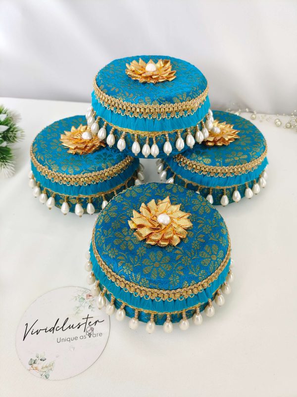Elegant blue laddu boxes adorned with golden floral patterns, golden floral motifs with pearls, and golden lace trim with white pearl beads. Perfectly crafted for barati gifts, bridesmaids gifts, and shagun ceremonies.