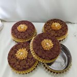 Beautiful brown laddu boxes with gold floral motifs and pearl decorations traditional sweets to present to guests, making them a functional and beautiful addition to the ceremony