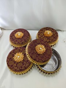 Beautiful brown laddu boxes with gold floral motifs and pearl decorations traditional sweets to present to guests, making them a functional and beautiful addition to the ceremony