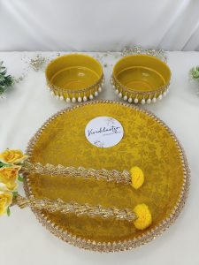 Haldi ceremony platter with yellow bowls, decorated with pearls and golden lace, perfect for weddings, and adorned with charming yellow flowers for wedding haldi celebration