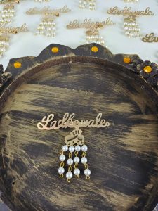 a pearl-embellished Ladkewale brooch. The brooch showcases an intricate design with pearls, suitable as a groom side badge or baarati brooch