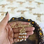 sophisticated Ladkewale brooch with pearl embellishments. The brooch features a refined design with delicate pearls, making it an ideal wedding favor and coat accessory